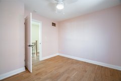 bedroom-with-light-pink-walls-hardwood-floor