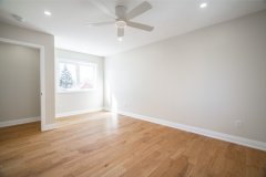 bedroom-with-white-walls-hardwood-floor-and-pot-lights