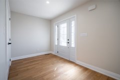 master-bedroom-with-white-walls-french-doors-and-hardwood-floors
