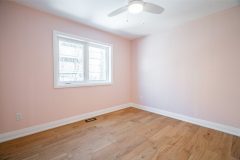 modern-bedroom-with-light-pink-walls-hardwood-floor-and-pot-lights-1536x1024