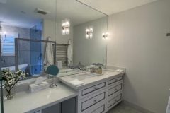 modern-bathroom-with-huge-mirror-and-white-vanities-450x600