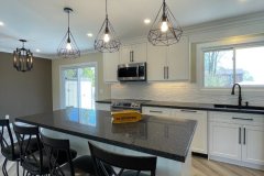 kitchen-island-with-black-countertop-and-pendant-lights